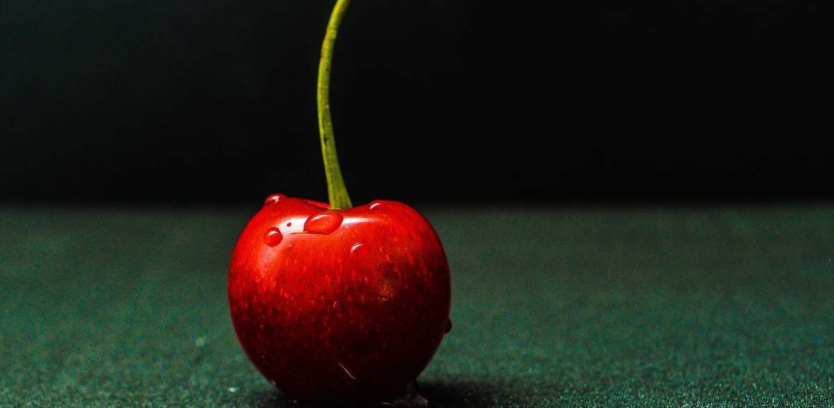 fruit red cheery on green surface apple