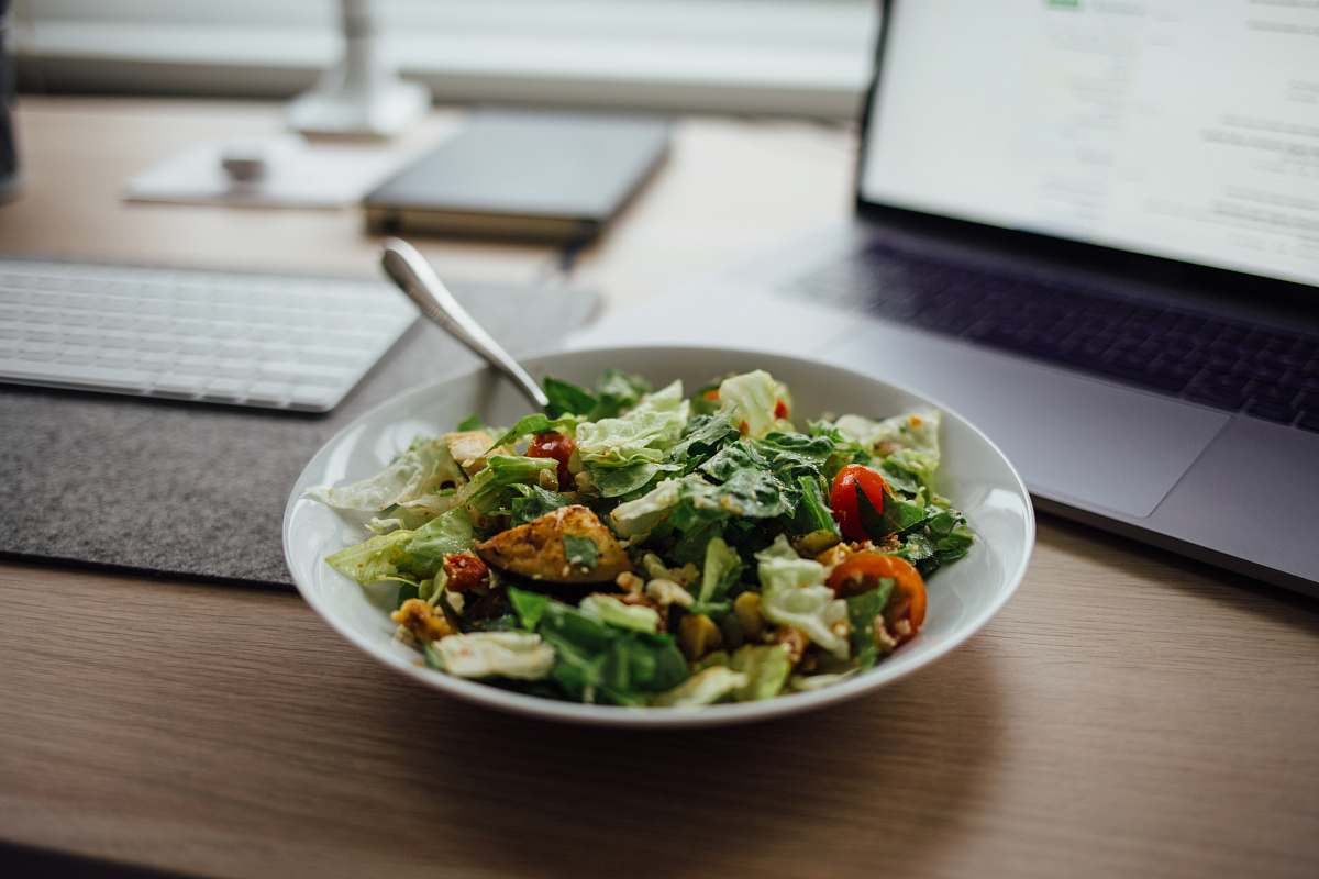 salad salad on white ceramic bowl on top of table near laptop meal
