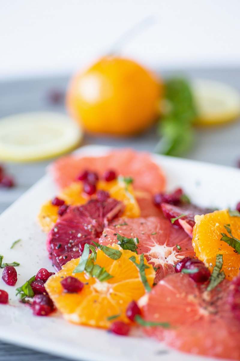 plant shallow focus photo of sliced fruits on white ceramic tray citrus fruit