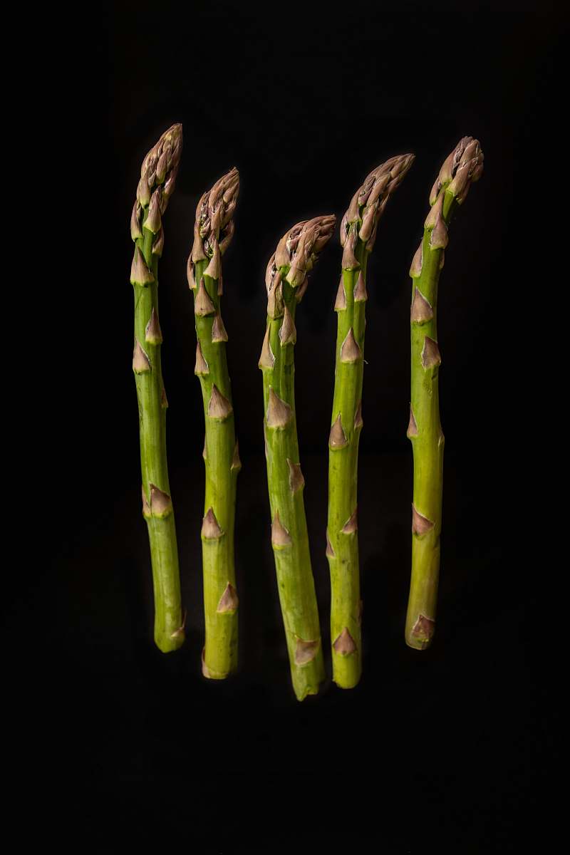 vegetable six green-and-brown asparagus with black background produce