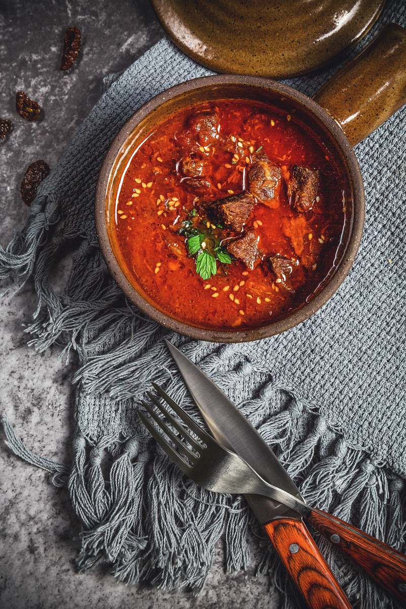 curry skewed meat in bowl beside knife and fork meat