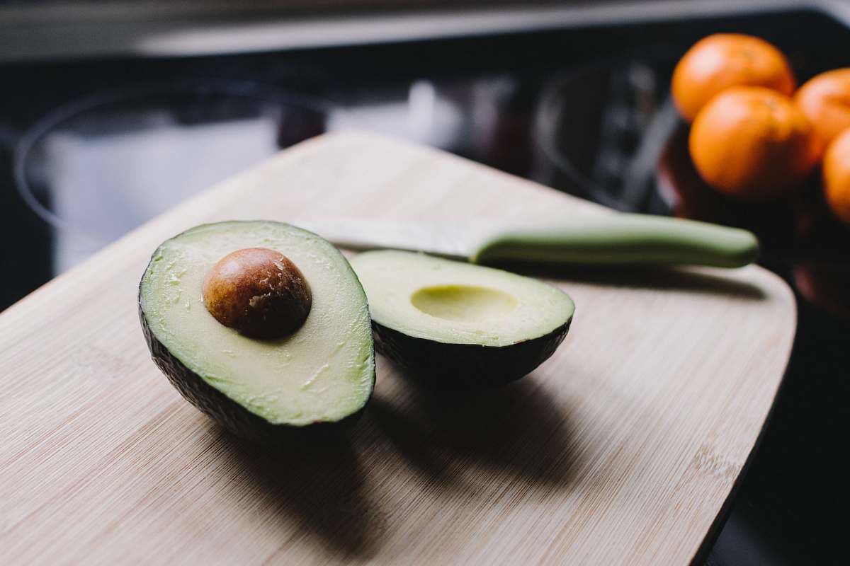 fruit sliced avocado on brown wooden chopping board avocado