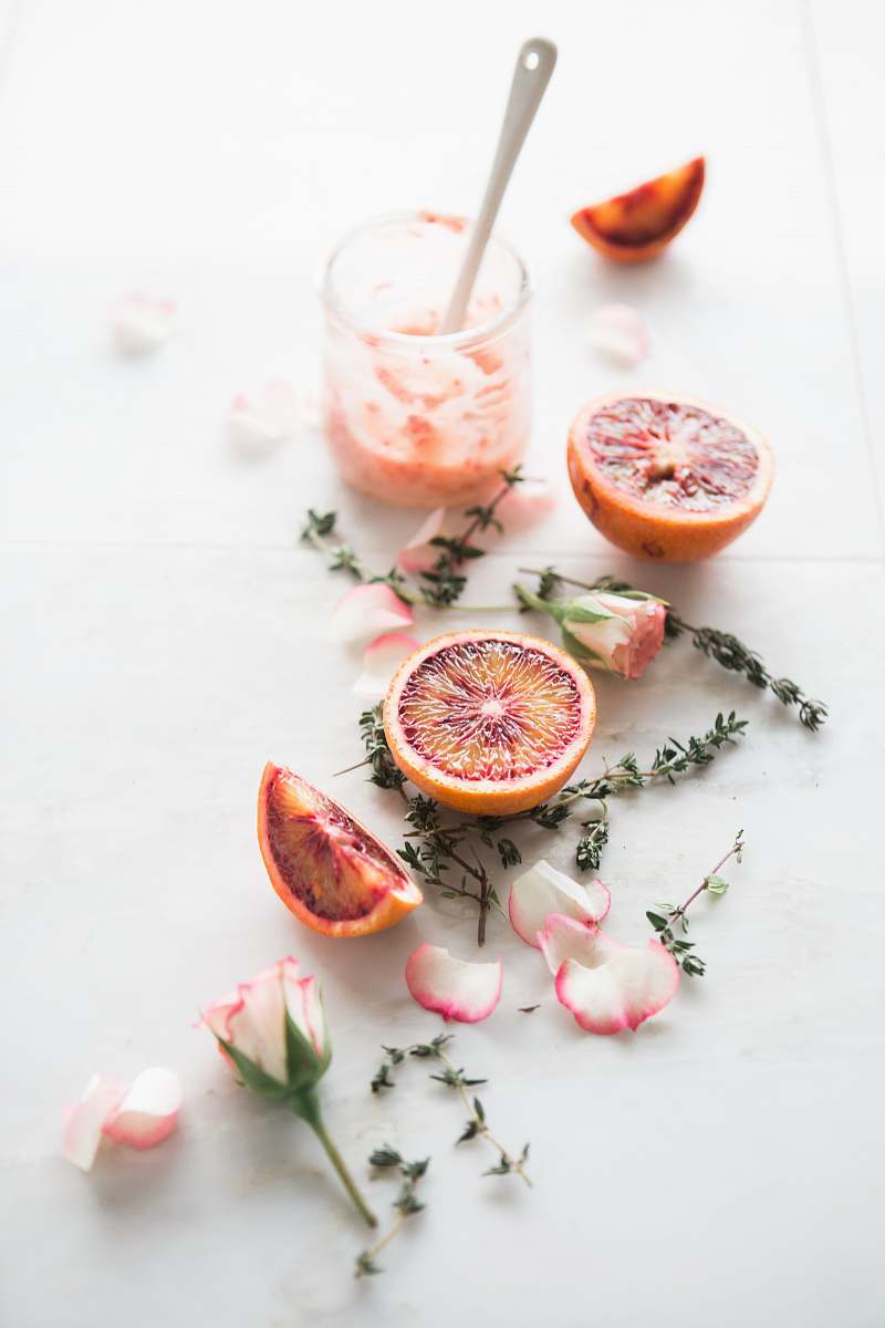 drink sliced blood orange fruits with white-and-pink petaled flowers beside fruit