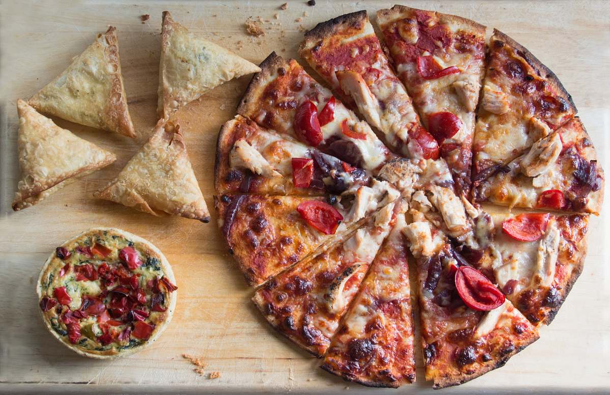 pizza sliced pizza on brown wooden table samosa