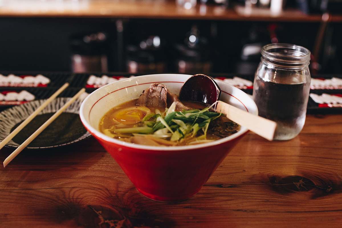 chicago soup with vegetable beside chopsticks and glass of water ramen