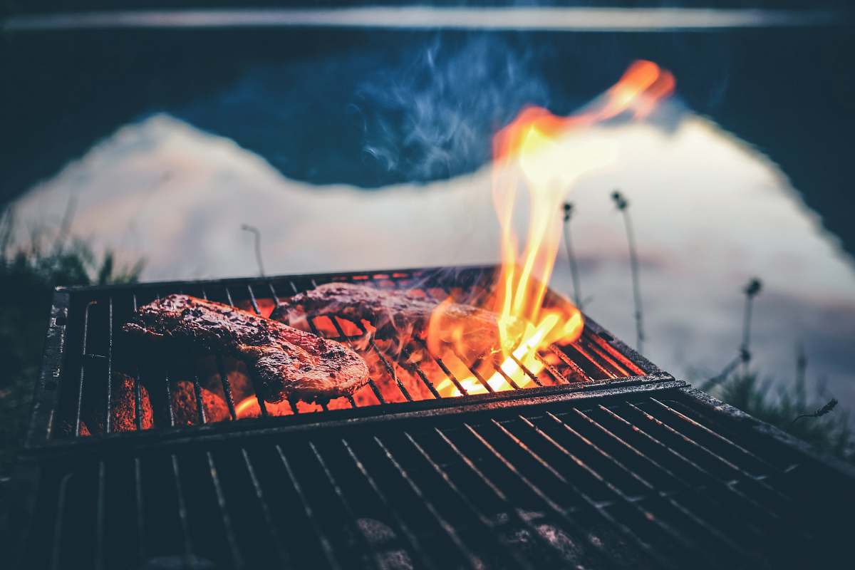 bbq steak on charcoal grill with fire fire