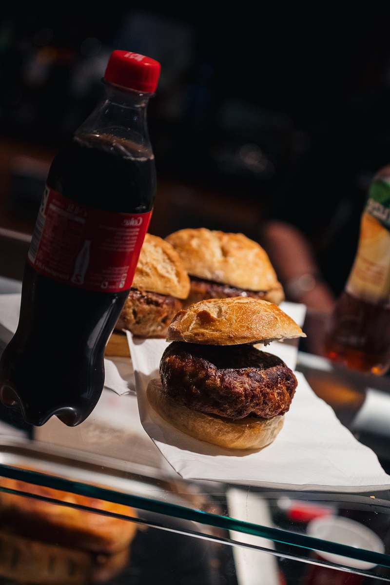 burger three burgers and bottle of Coca-Cola on table alcohol