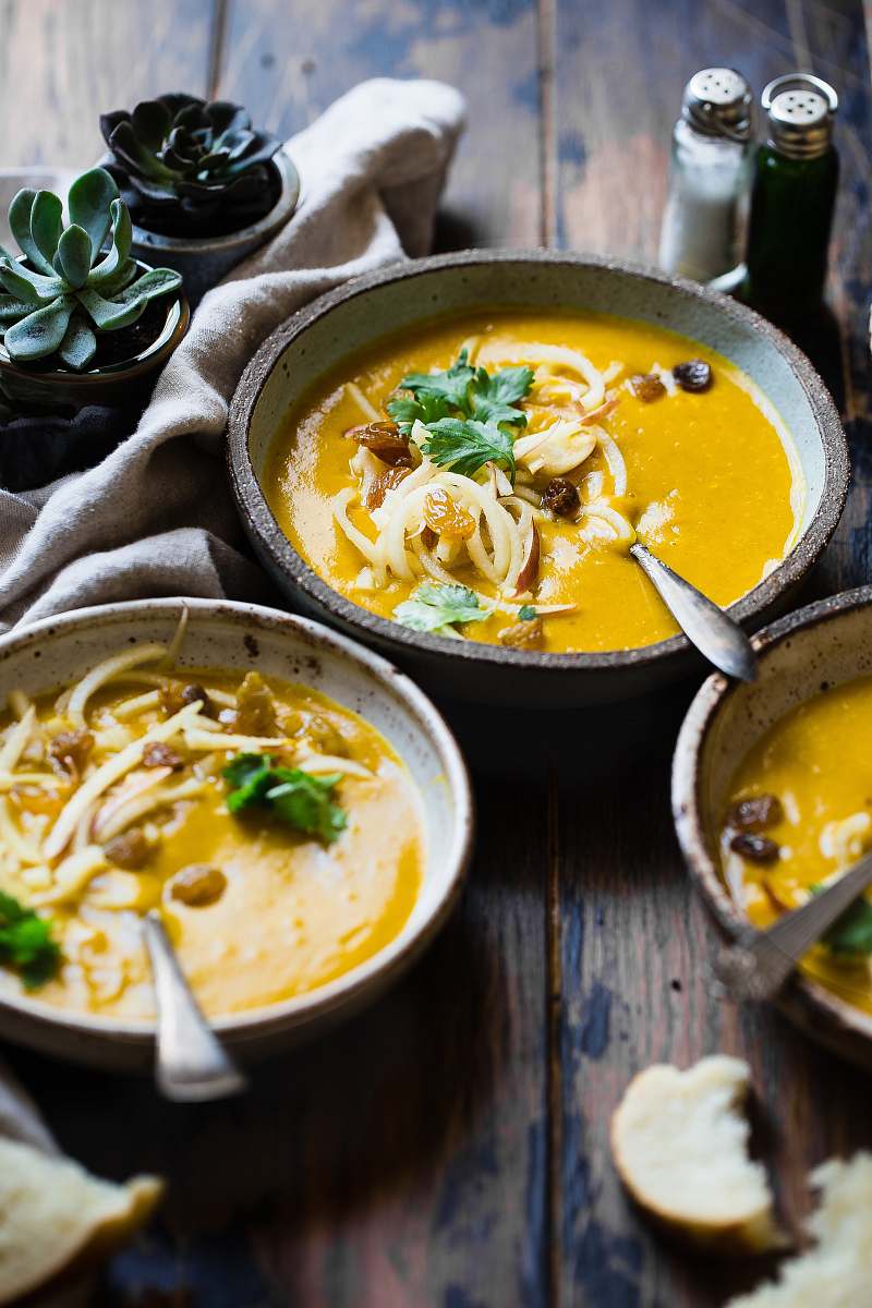 plant three noodle dishes with orange sauces in food photography soup