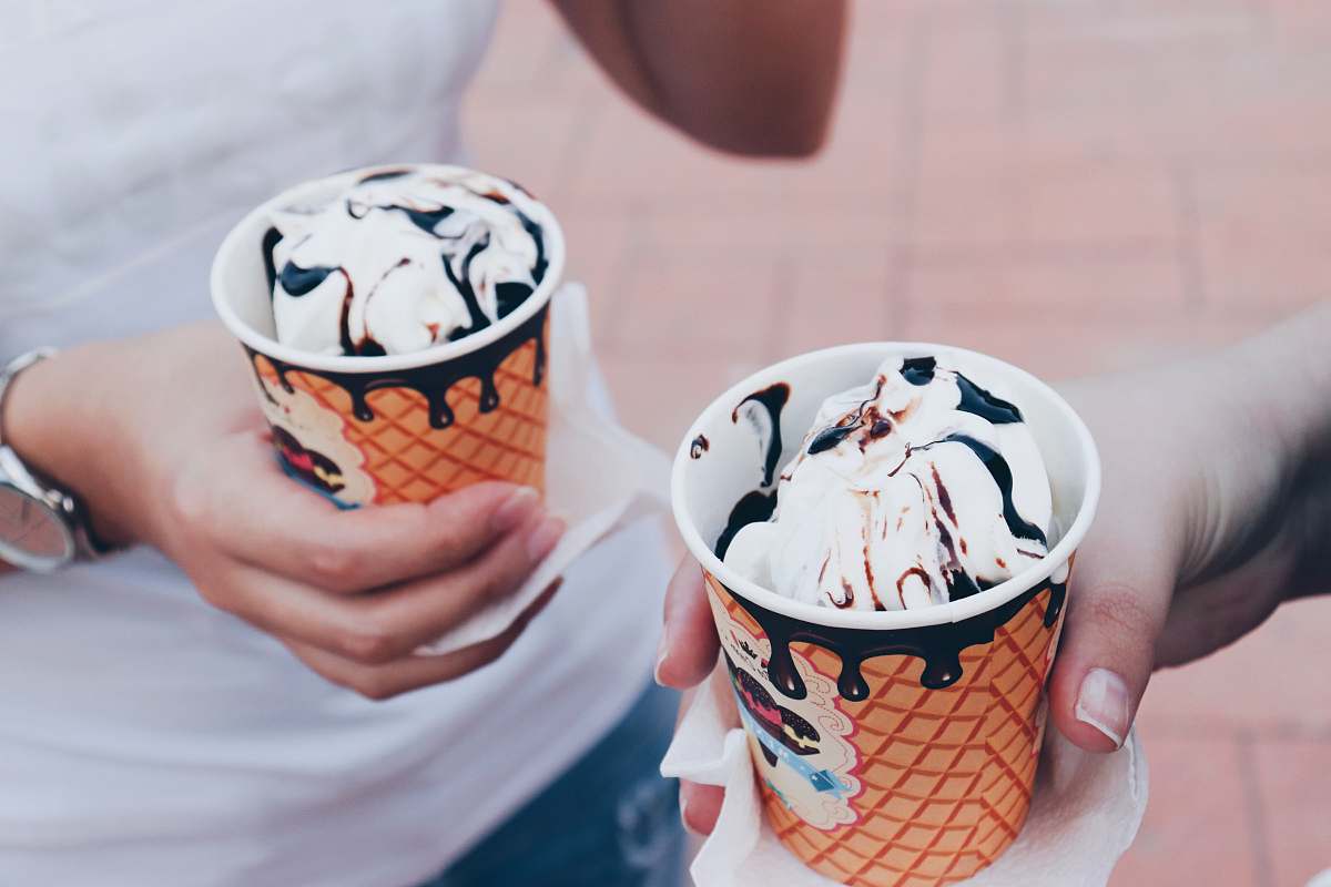 dessert two person holding white icings with disposable cap creme
