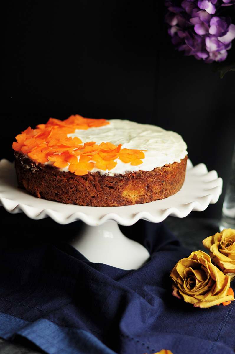 dessert white and orange icing-coated cake on scalloped edge white ceramic cake stand cake