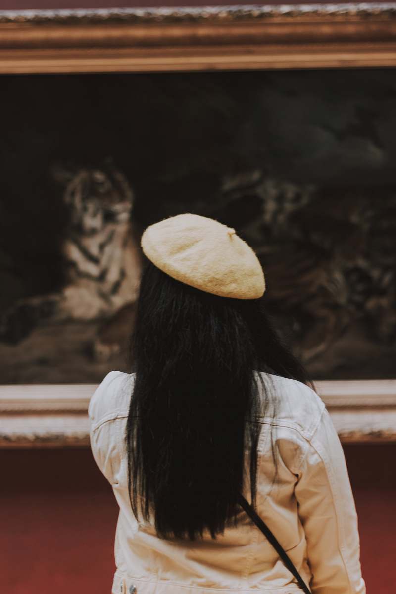 bread woman in white hat facing painting pita