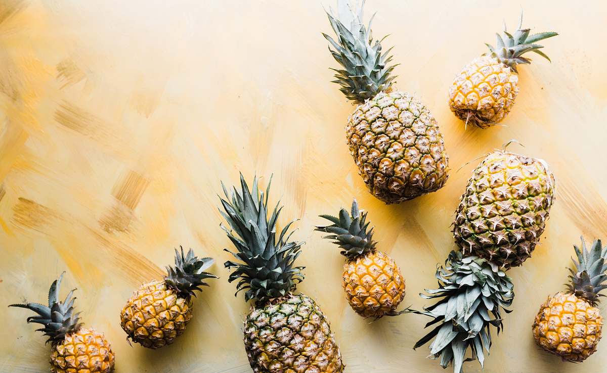 pineapple pineapples on brown surface food