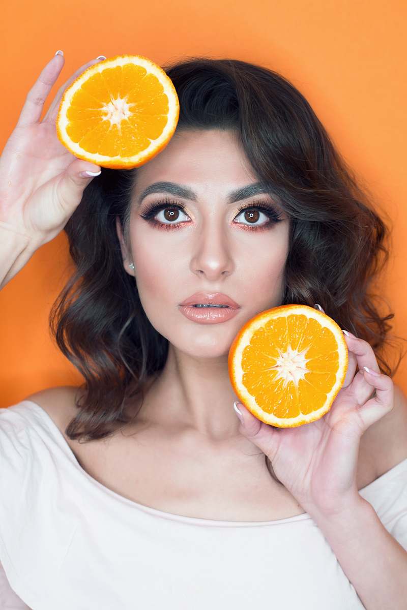 plant woman in white shirt holding sliced lemons citrus fruit