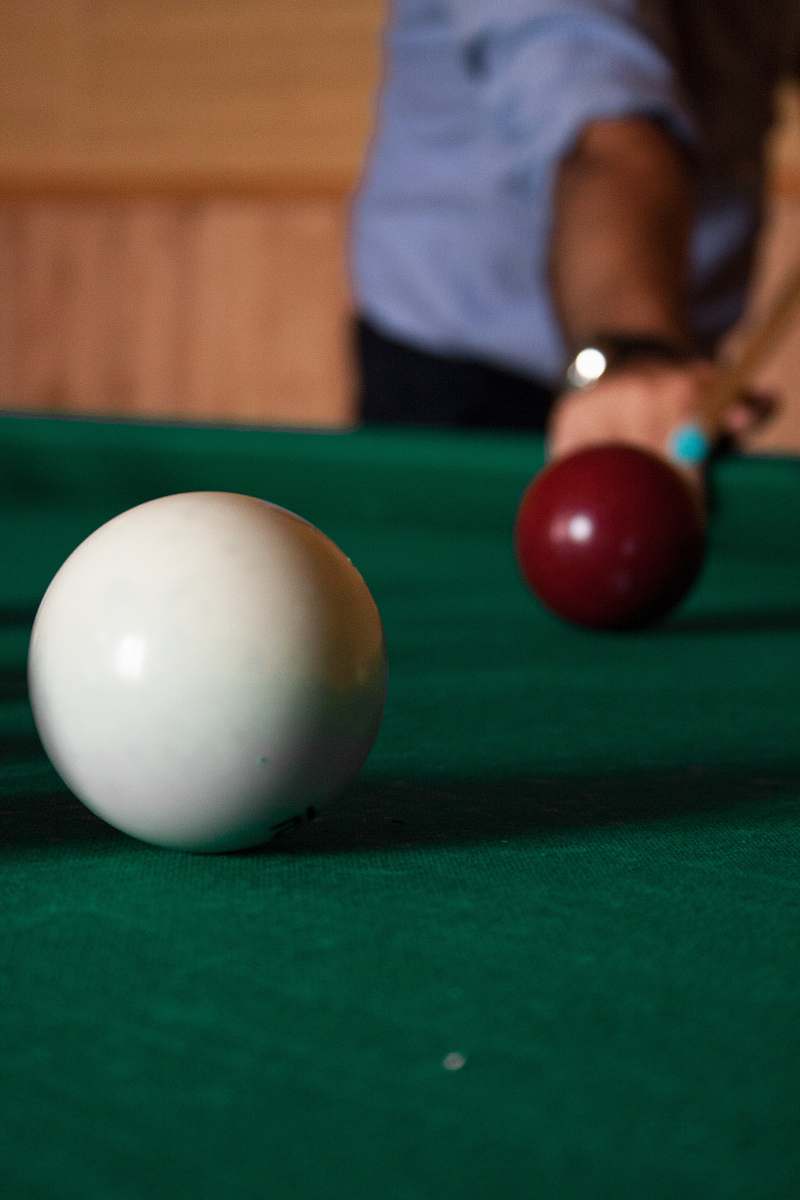 indoors person playing billiard room