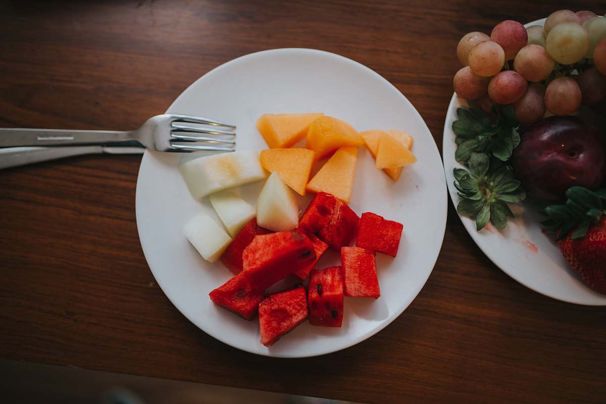 fork sliced watermelon and mango on plate with fork cutlery