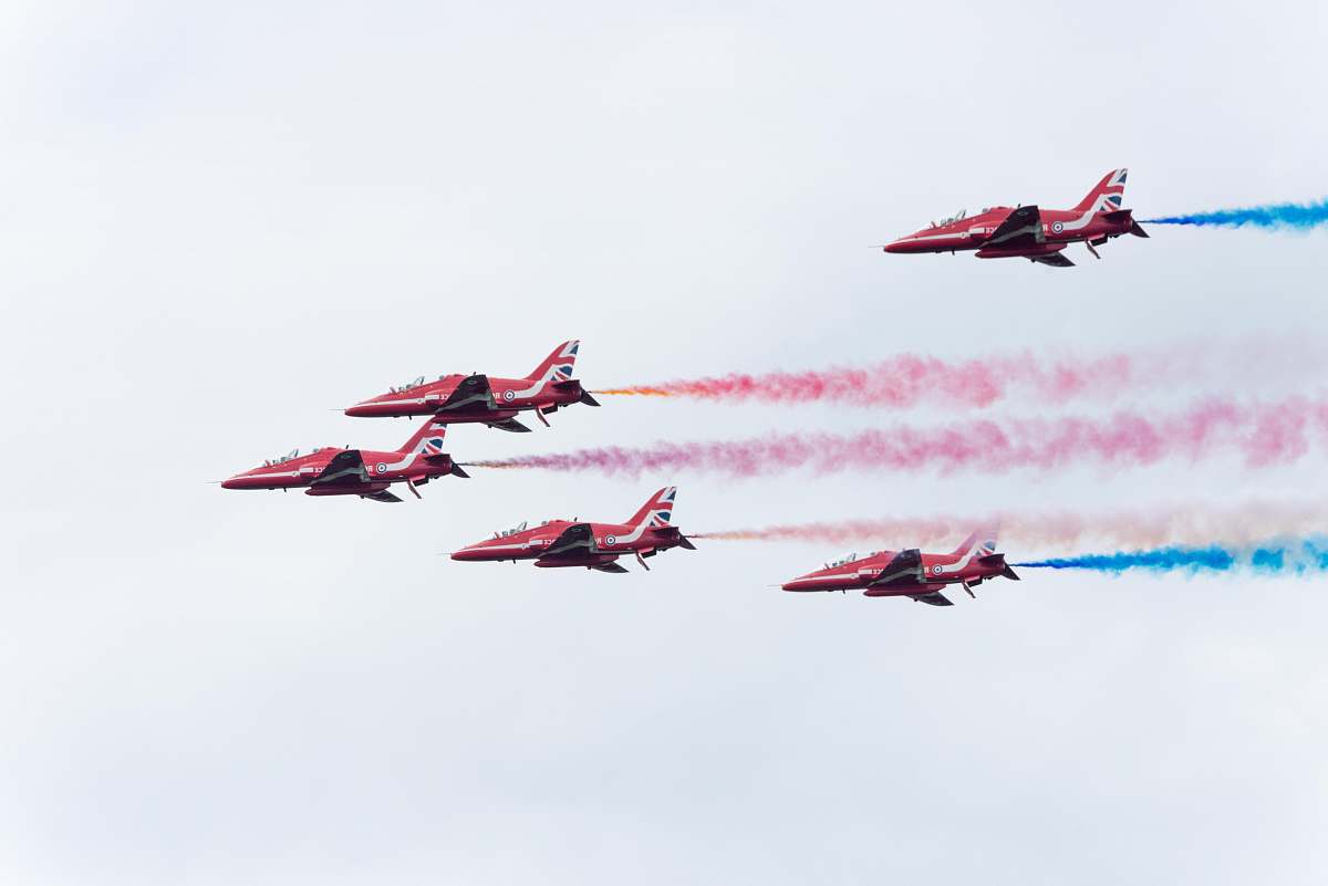 bird five pink planes with teal and pink smokes flying