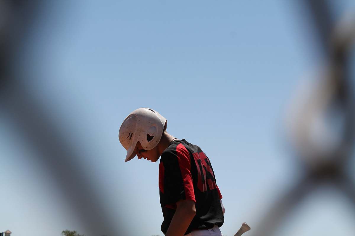 human baseball player looking down person