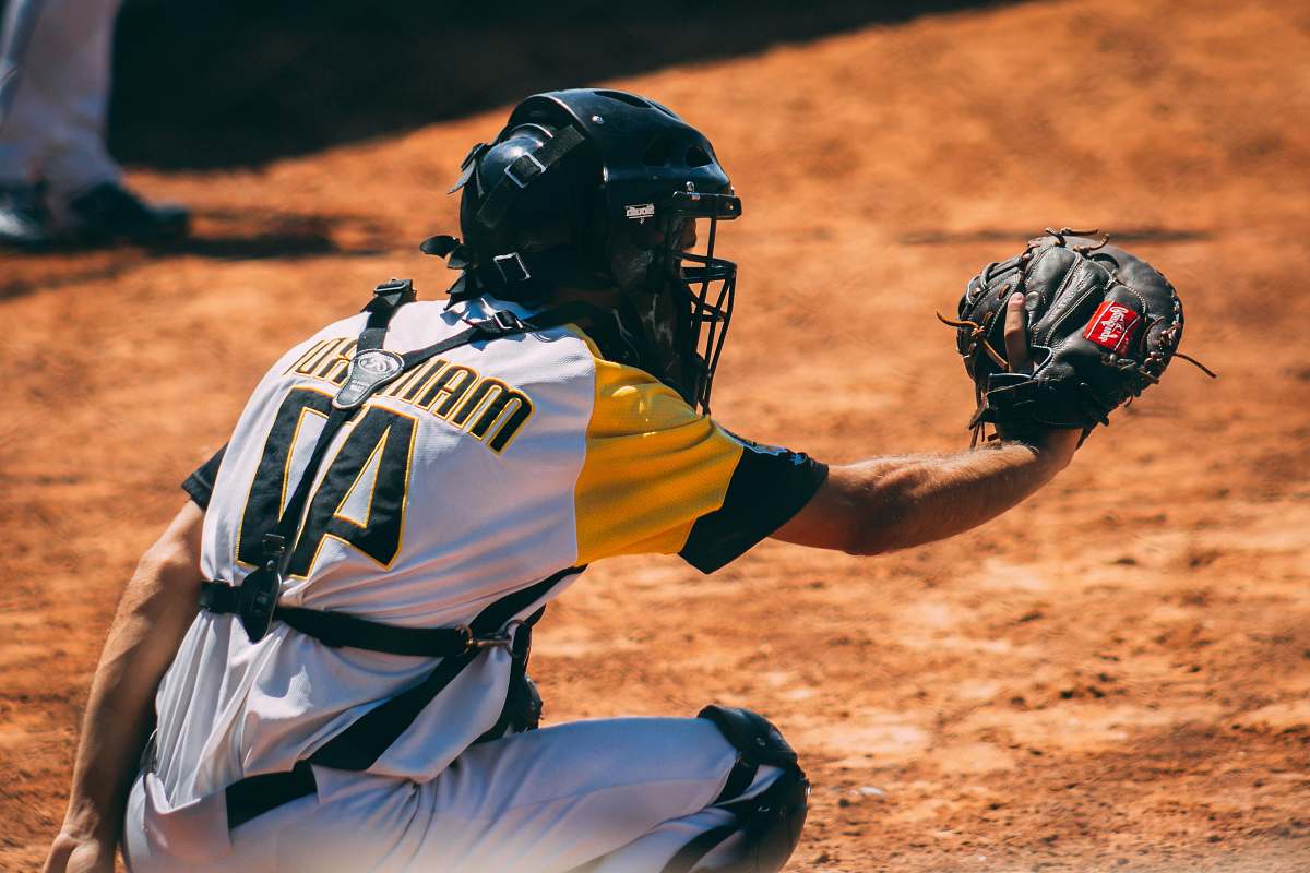 clothing man sitting and about to catch ball helmet