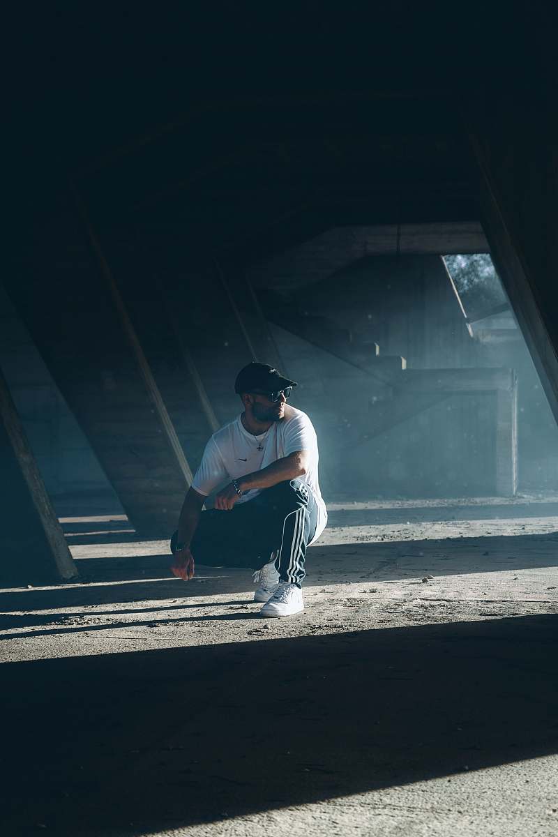 clothing man sitting on a parking lot human