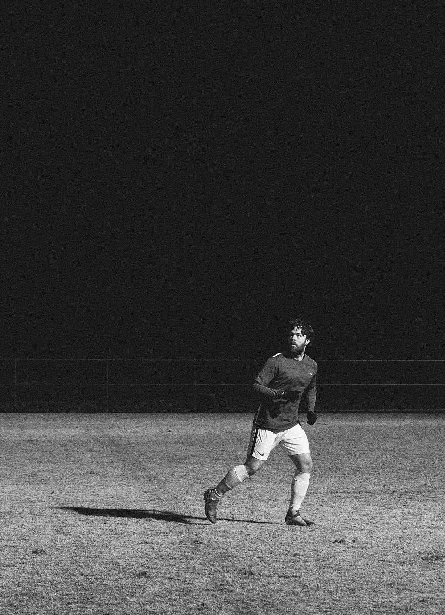 clothing man wearing black sweater running at grass field black-and-white