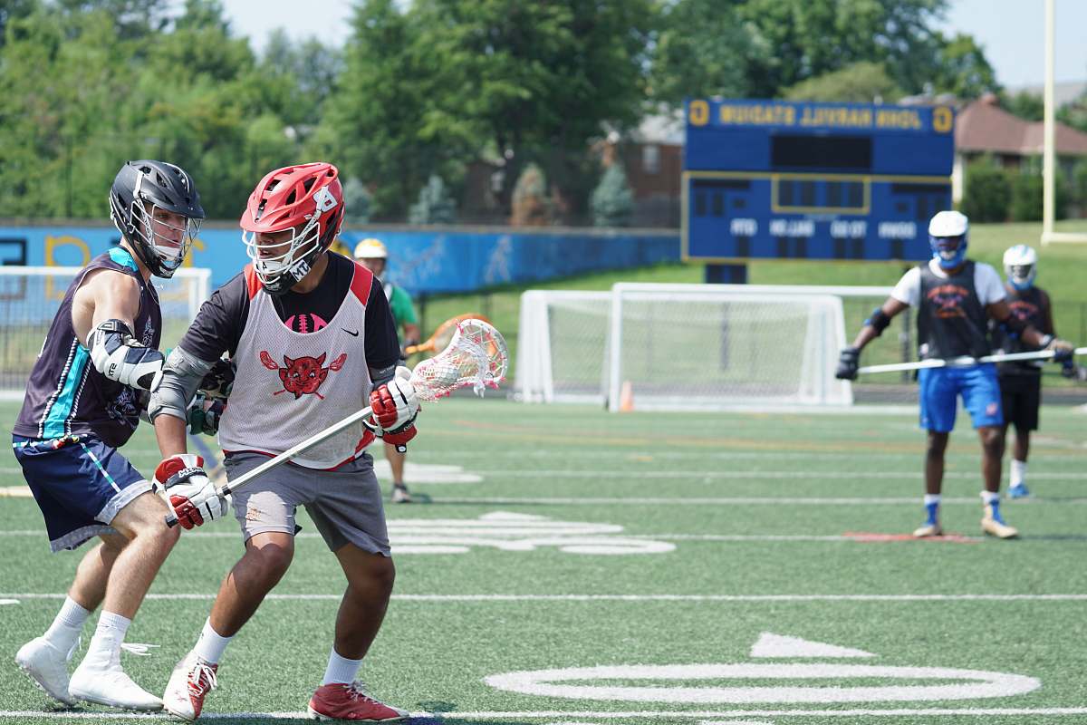 human people playing lacrosse during daytime person