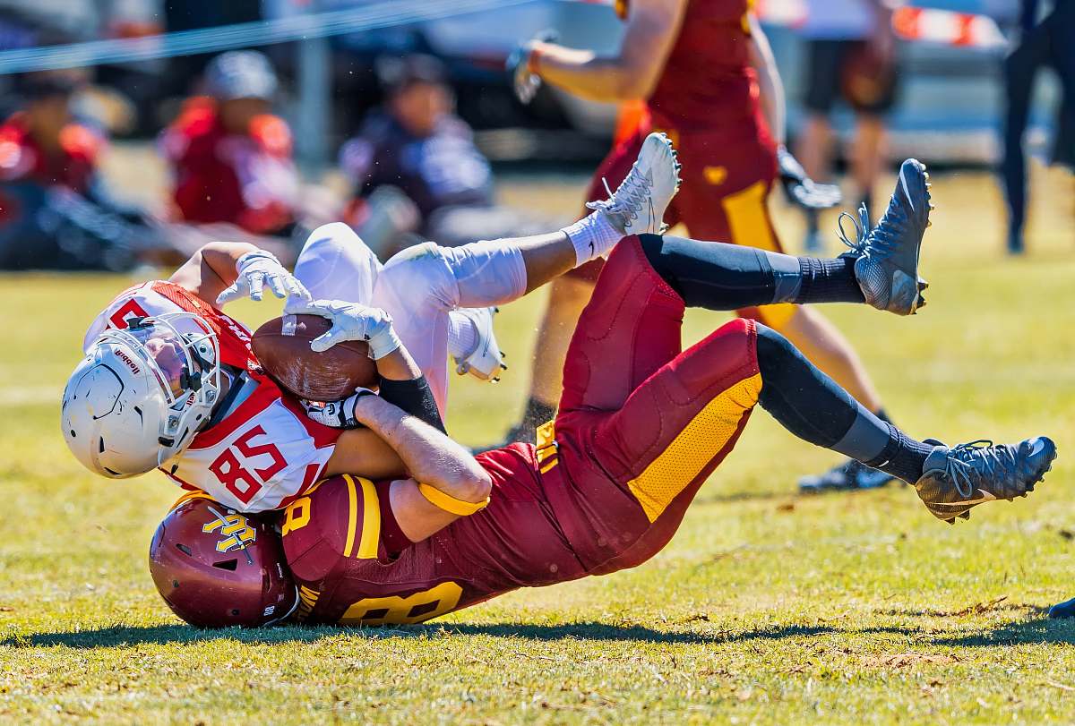 clothing selective focus photography of two football players fighting of the ball during daytime team