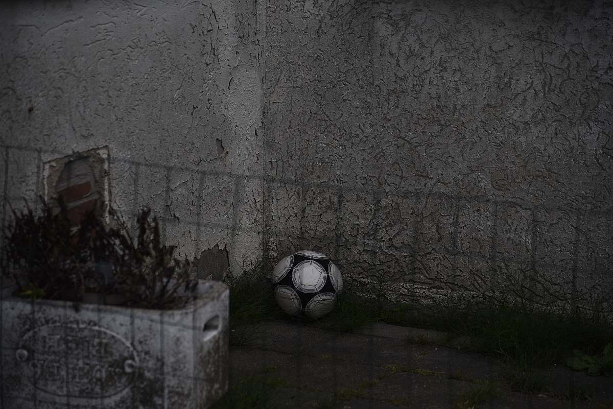 grey white and black ball near gray fence football