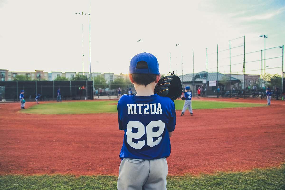 sport boy in blue and white shirt standing on green grass team sport