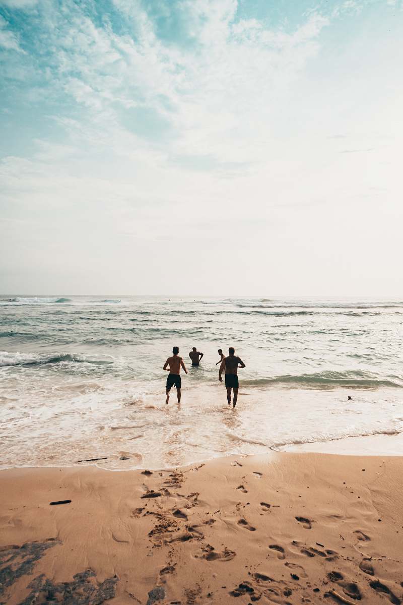ocean men running toward beach coast