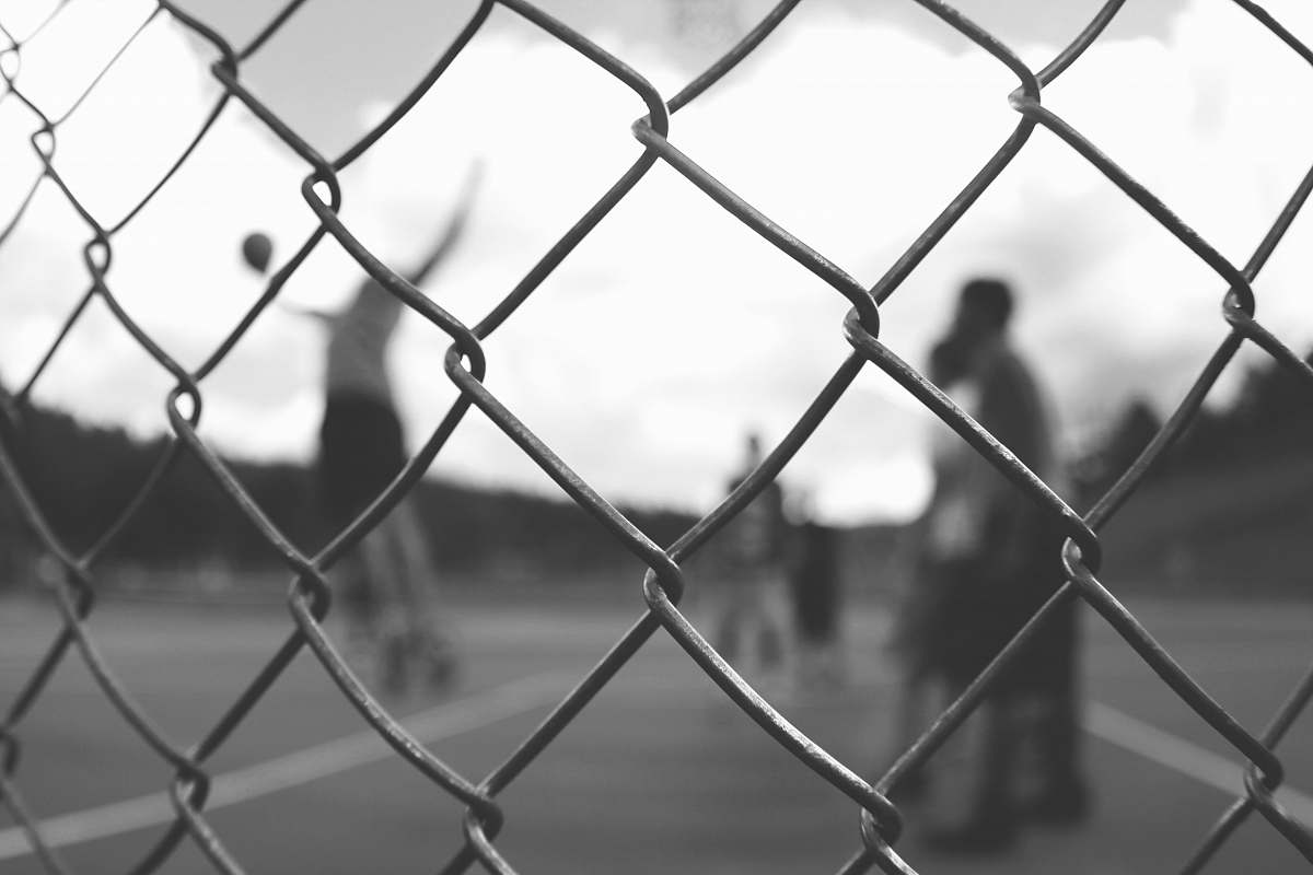 sport grayscale photo of cyclone fence fence