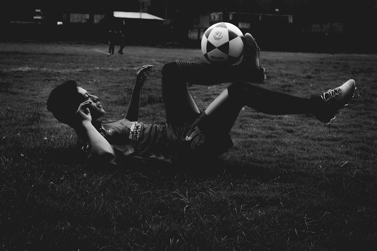 human man lying on field while playing soccer ball person