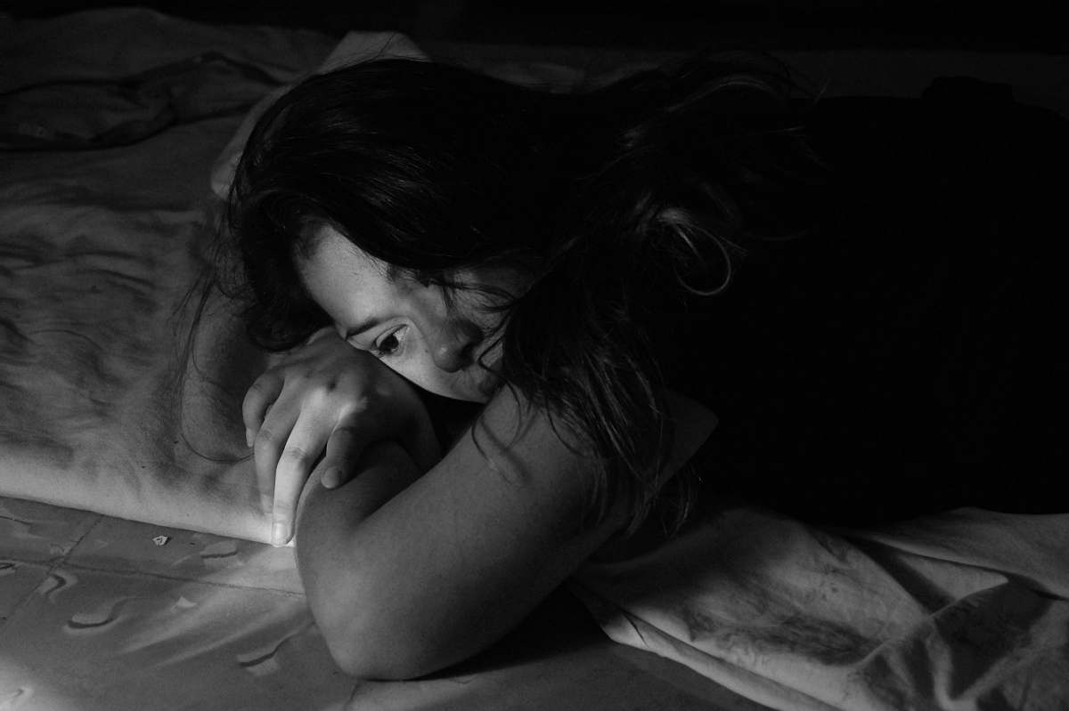 black woman leaning on bed woman