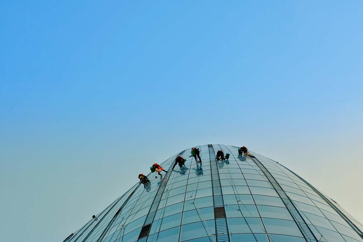 building people hanging on building ferris wheel