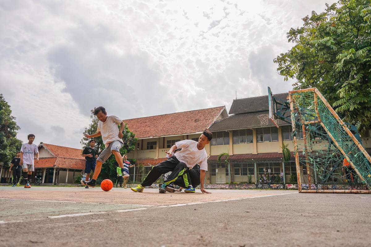 human men playing soccer during daytime person