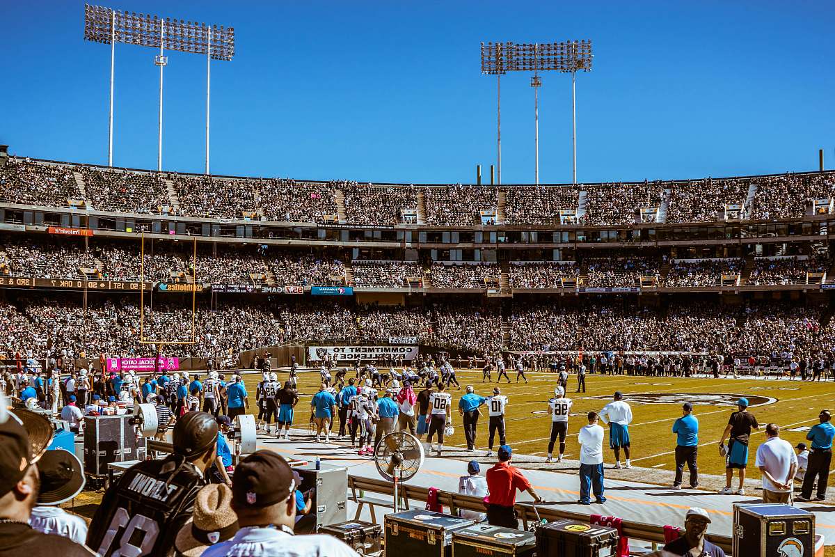 spectator group of people watching football game during daytime football