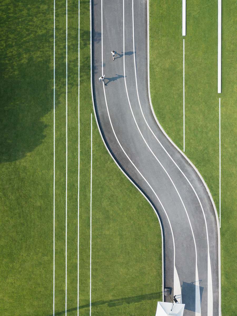 sports aerial photography of two person running on road during daytime sport