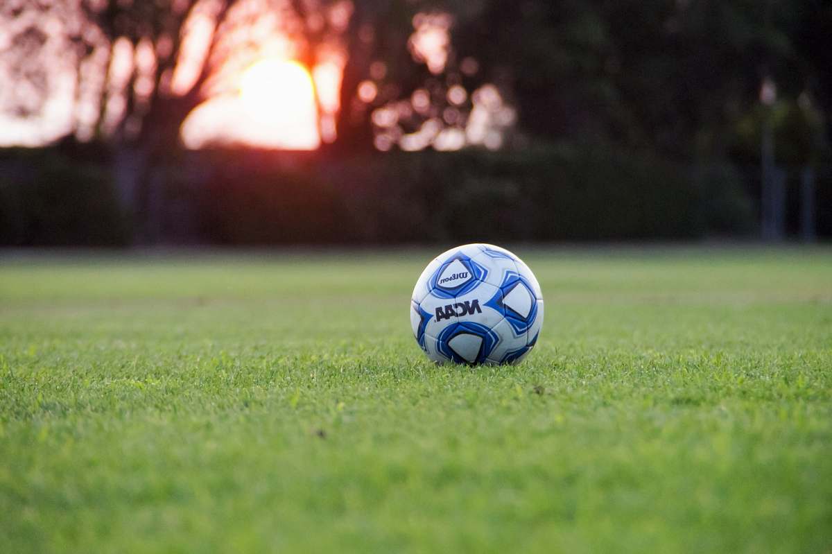 ball white and blue NCAA soccer ball on green grass field soccer