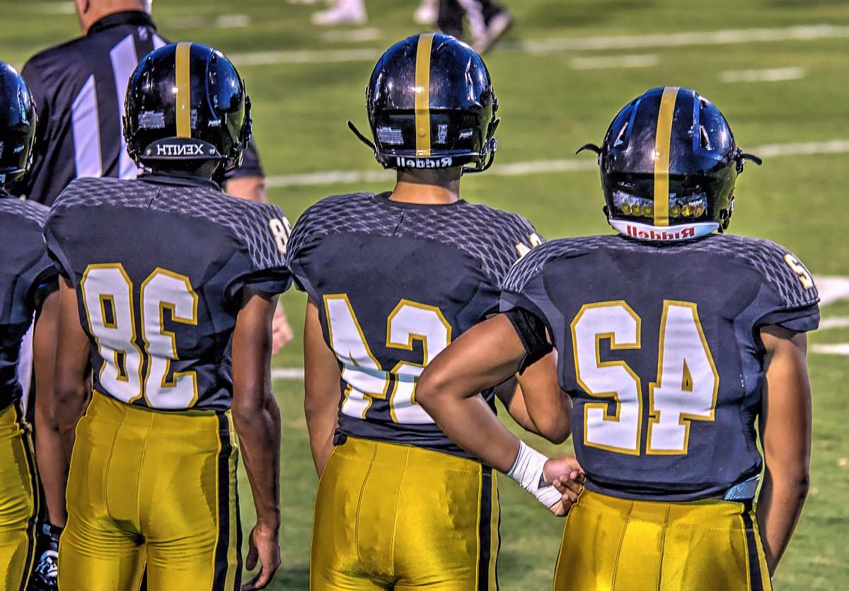 football three football players standing on football field sports