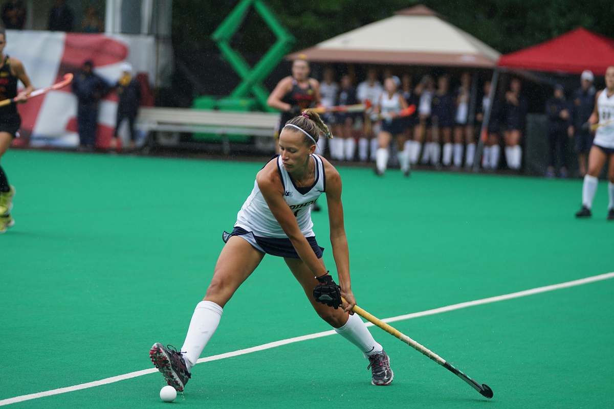 human woman holding hockey stick on field people