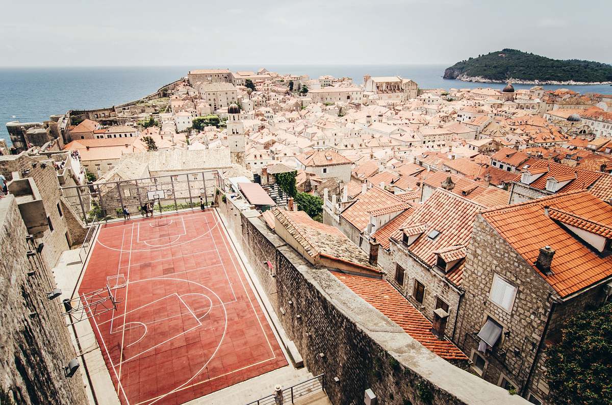 person aerial photo of houses near basketball court during daytime people