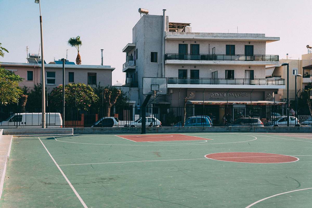 person basketball court near building during daytime sport