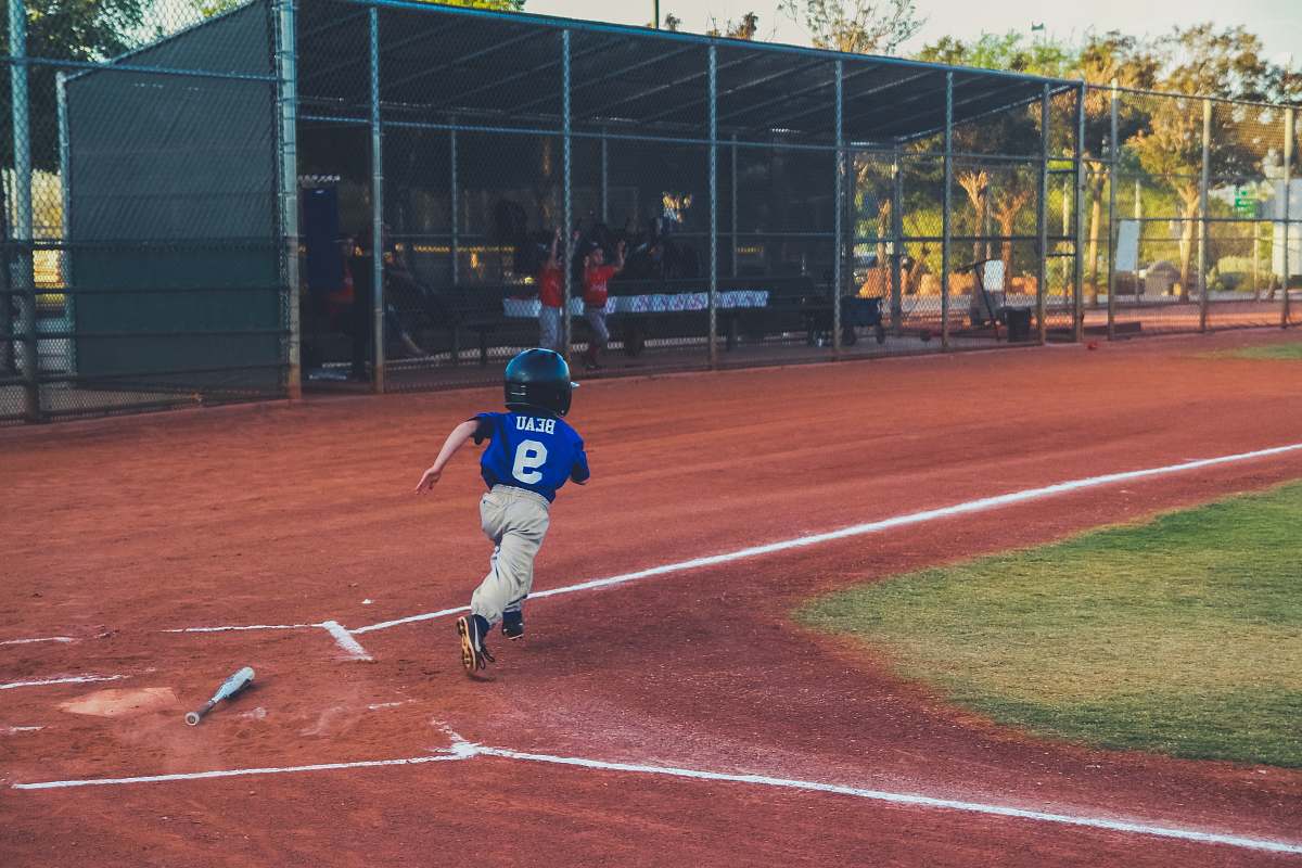 person boy hit the ball running for the next base people