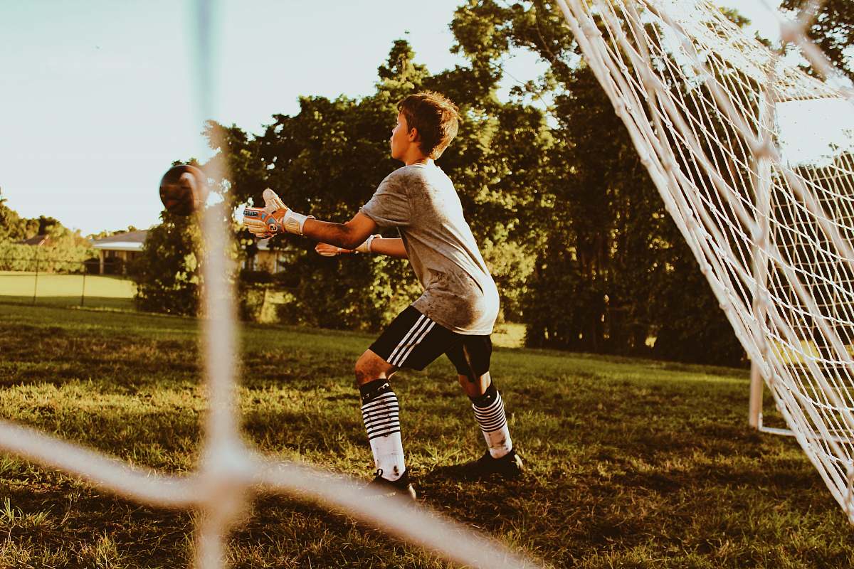 person boy standing near net goal apparel