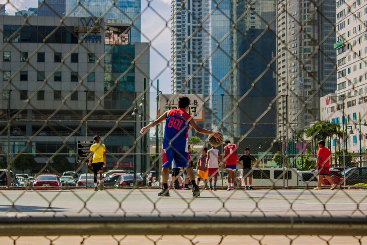 person boys playing basketball on outdoor court during daytime automobile