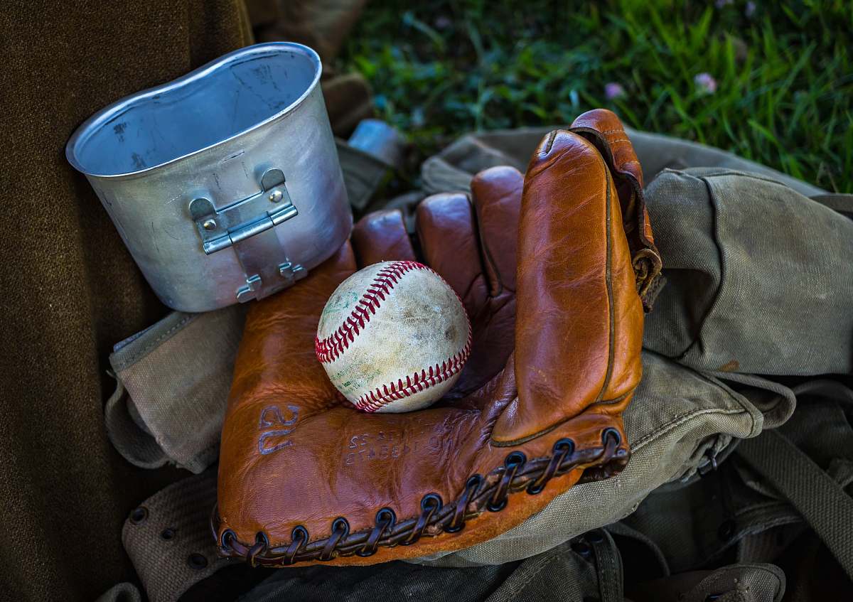 sport brown leather baseball mitt with baseball beside gray container and brown textile at daytime baseball