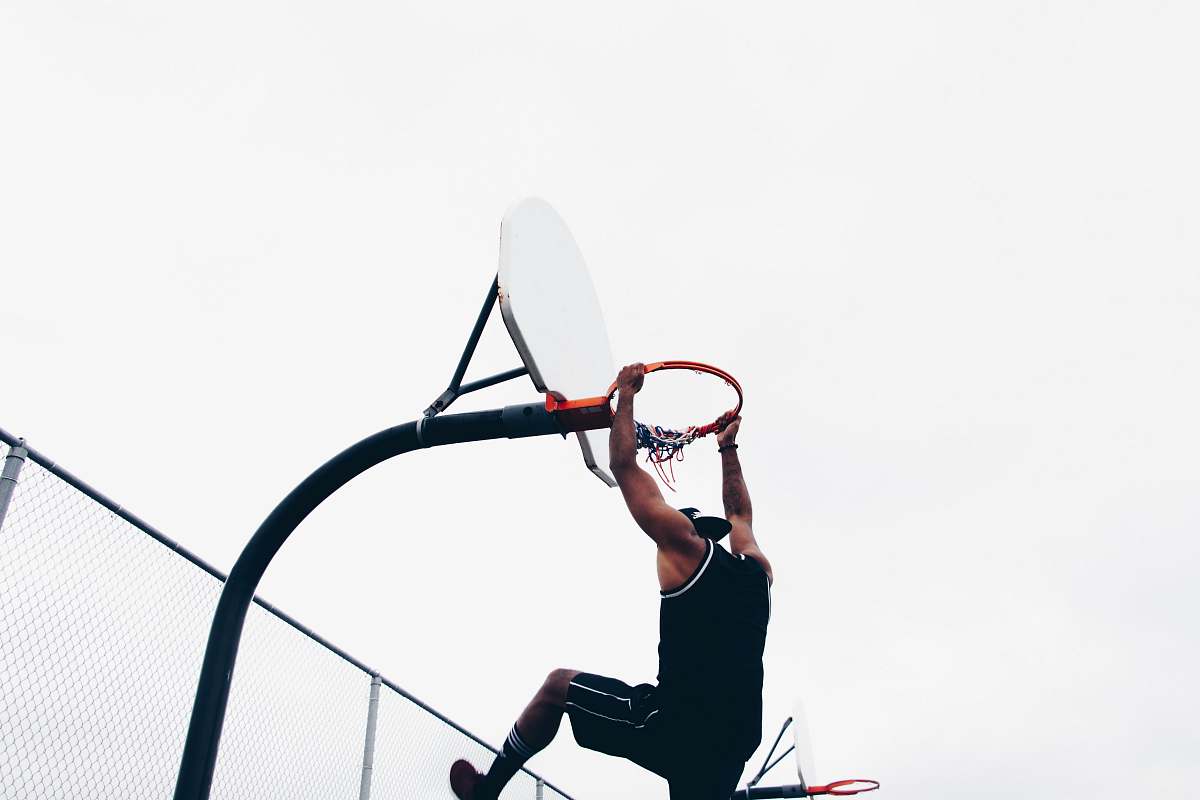 person close-up photography of man dunking on basketball hop detroit