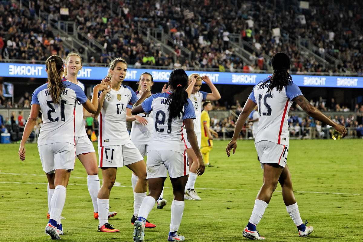 person female soccer players at the field near people on bleachers people