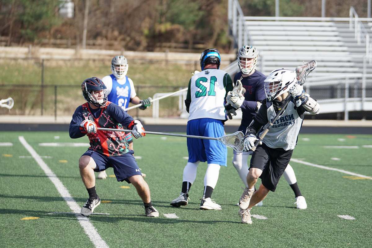 apparel five men playing lacrosse on field clothing