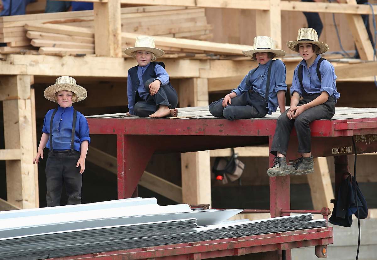 person four boys sitting on red steel frame people