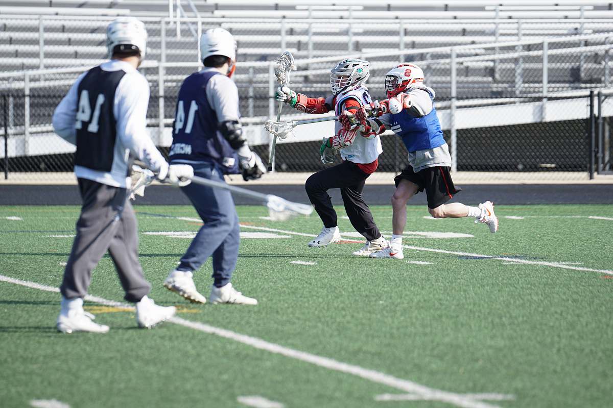 person four men playing lacrosse apparel